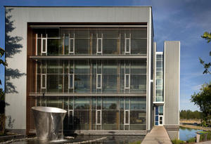 This photo shows the west façade, including the water feature and an office entry bridge. - Photo Credit: Nic Lehoux
