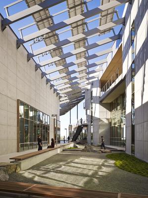The courtyard and garden connect the two building wings, promoting collaboration amongst researchers. Photovoltaic arrays provide energy to the building and shade to the courtyard. - Photo Credit: © Nick Merrick