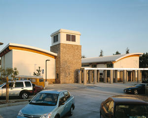 This photo shows the library's entry with community room facilities at the left. The passive cooling tower and environmental awareness center are located at the entry plaza. The trellis glazed with photovoltaic panels fronts the reading room wing. - Photo Credit: RMA Photography, Inc.