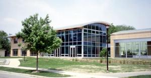 The Lewis Center is located at 122 Elm St. The building was designed to fit into the site. On the east (the left in this photograph) is residential town area, so this side of the building is primarily brick and of a relatively conservative design. The north side of the building is buffered by a productive garden as well as an immature orchard. A constructed wetland, visible on the right half of the photo, wraps around the south and east sides of the building. - Photo Credit: Oberlin College