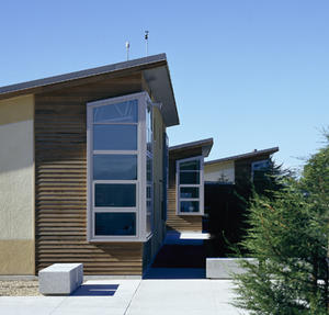 This photograph shows the exterior of the classroom building, featuring large north-facing windows that wrap the corner of the building to balance the light. - Photo Credit: Michael David Rose