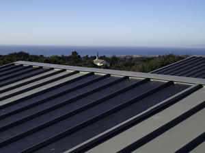 This project features a cost-effective photovoltaic installation in which the photovoltaic panels are applied directly to the standing-seam metal roof, as shown in this photograph. - Photo Credit: Michael David Rose