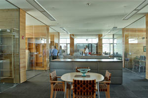 The program offices shown in the photo feature reclaimed wood dividers and a reflective, stretched-fabric ceiling. - Photo Credit: Nic Lehoux