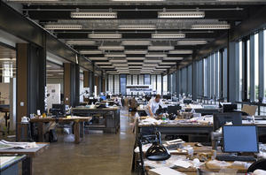 This interior photo shows the building's studio space with exposed systems and flexible lighting fixtures. - Photo Credit: © Peter Aaron/Esto
