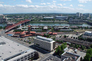 Aerial view of Bud Clark Commons showing its vital urban context. BCC sits on the western border of Old Town/Chinatown, an emerging historical neighborhood in Portland, and the eastern border of the Pearl District, an upscale mixed-use neighborhood. Its visibility from Portland's bustling train station, directly to its north, and from the Broadway Bridge, symbolizes the city's dedication to ending homelessness. - Photo Credit: SkyShots
