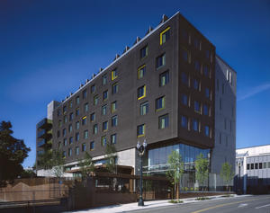 View of Bud Clark Commons from the northeast, including custom entrance gate that leads to public courtyard for the homeless seeking services and shelter. - Photo Credit: Sally Schoolmaster