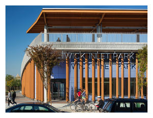 View of Community Center entrance, showing wood louvers and rooftop canopy, phenolic panel rainscreen and custom stainless steel railings - Photo Credit: © Paul Warchol