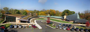 This photo shows a panoramic aerial view of the original Meeting House and new addition. Parking was considered part of the "historic fabric" of the original design. - Photo Credit: The Kubala Washatko Architects, Inc.