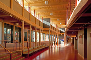 Sustainably harvested red pine columns line the daylight-filled lower crossing and commons area seen in this photo. - Photo Credit: The Kubala Washatko Architects, Inc. / Zane Williams