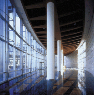 Use of local materials, including concrete and aluminum for the outer wall and wood, glass, stone, and plastered gypsum for the interior flooring and wall systems, allowed the building to be extremely economical while minimizing total embodied energy for its fabrication and construction. This interior photo shows several material choices. - Photo Credit: Daniela MacAdden