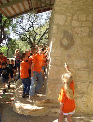 The students in this photo are discovering the fossils hidden in the walls of the building. - Photo Credit: Ron Sprouse
