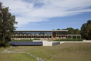 This photo shows the building's facade from the south, including the photovoltaic array and constructed wetlands. - Photo Credit: © Assassi