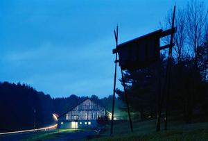 This photo shows the barn at night beyond the onsite bat house. - Photo Credit: Nic Lehoux