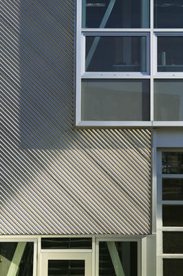 This photograph shows a detail of the facade with stainless steel cladding. - Photo Credit: Richard Mandelkorn