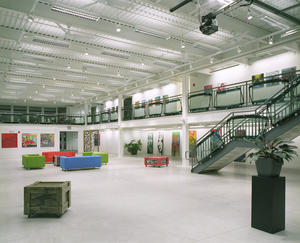 This photograph shows the naturally ventilated gallery space showcasing student art. Recycled windshields are used as guardrails. - Photo Credit: Richard Mandelkorn