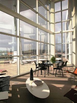 The glass-enclosed multi-purpose interior patio in this photograph, immediately adjacent to the main entrance, is available for work groups and team meetings. - Photo Credit: Kevin Beswick: People, Places and Things Photographic