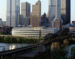 This photo shows PNC's south facade with the central business district beyond. The river and light-rail transit are visible in the foreground.