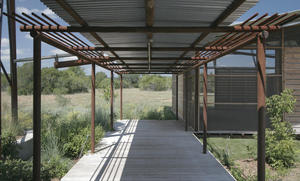 Circulation occurs outdoors on porches, like the one shown in this photo, reducing conditioned interior space, framing views, and providing connections to nature. - Photo Credit: Chris Cooper